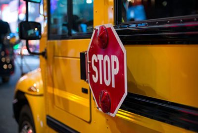 Stop sign on side on yellow School Bus